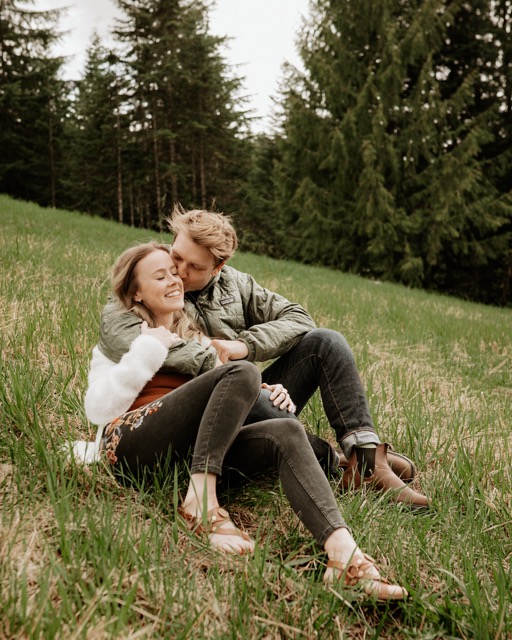Couple sharing a kiss with mountain backdrop